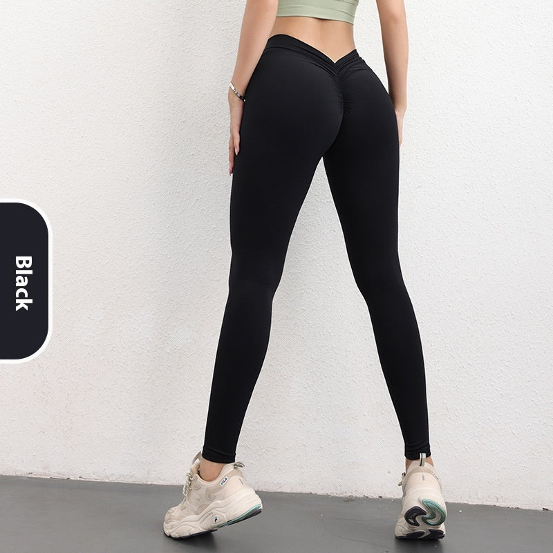 FashionRay black high-waisted leggings, scrunch detail, worn with sneakers, minimalist backdrop