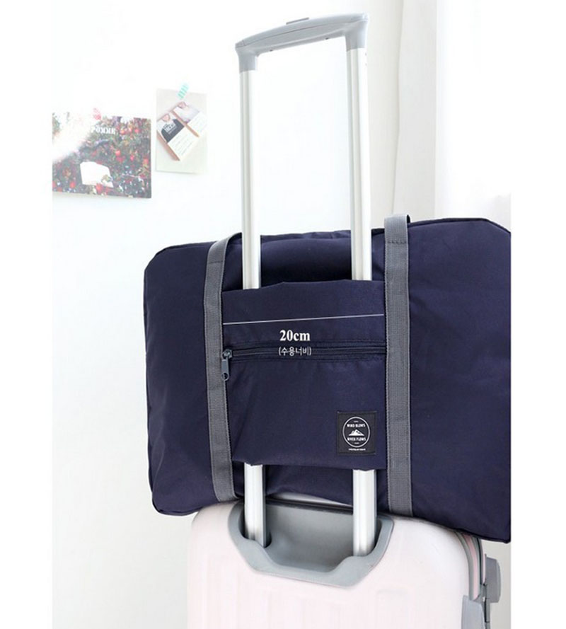 Navy travel tote bag on white suitcase, showcasing 20cm handle sleeve, FashionRay style