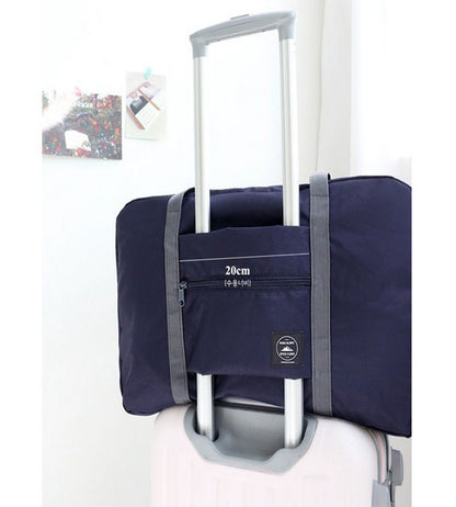 Navy travel tote bag on white suitcase, showcasing 20cm handle sleeve, FashionRay style