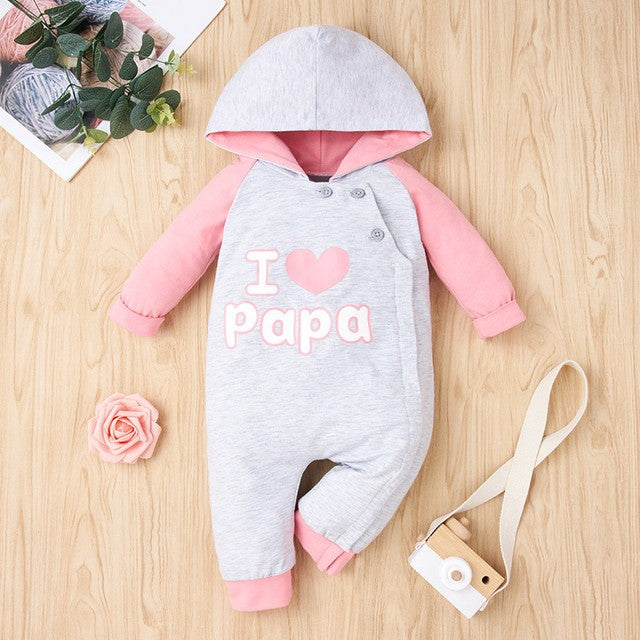 Gray and pink baby romper with 'I love papa' text, flat lay on wood with flower and toy, FashionRay