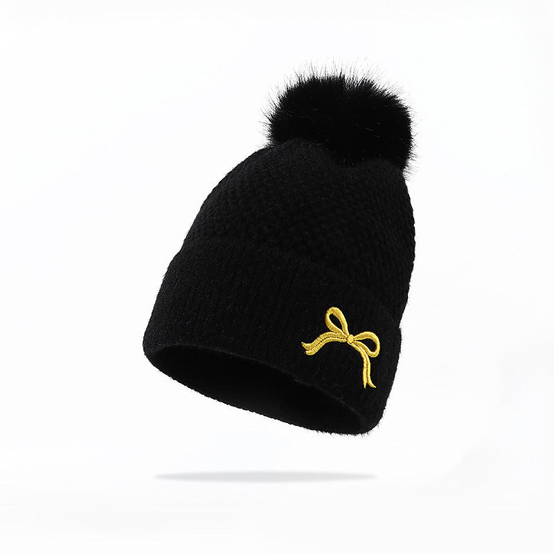 Black knit beanie with faux fur pom pom and yellow bow accent, FashionRay trendy winter hat