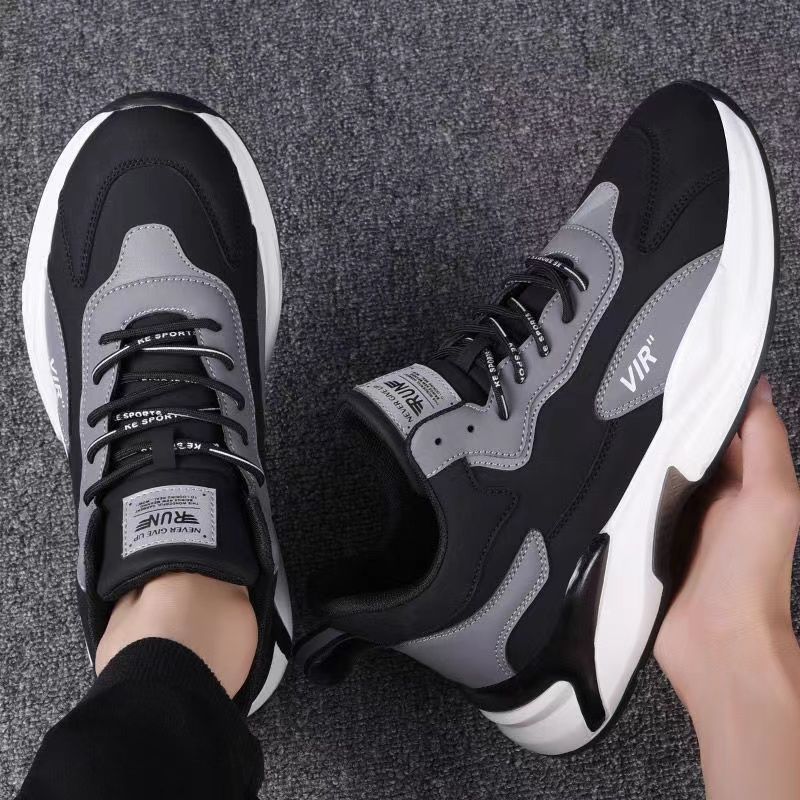 Black and grey chunky sneakers with white sole on gray carpet, FashionRay trendy footwear