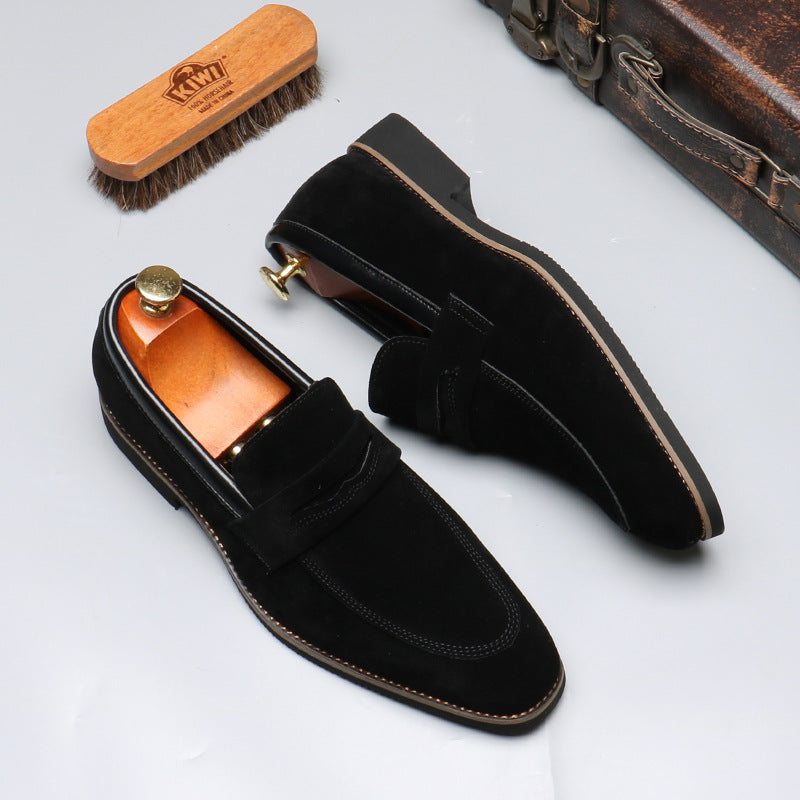Black suede men's loafers with wooden shoe trees, Kiwi brush, and vintage suitcase on FashionRay.